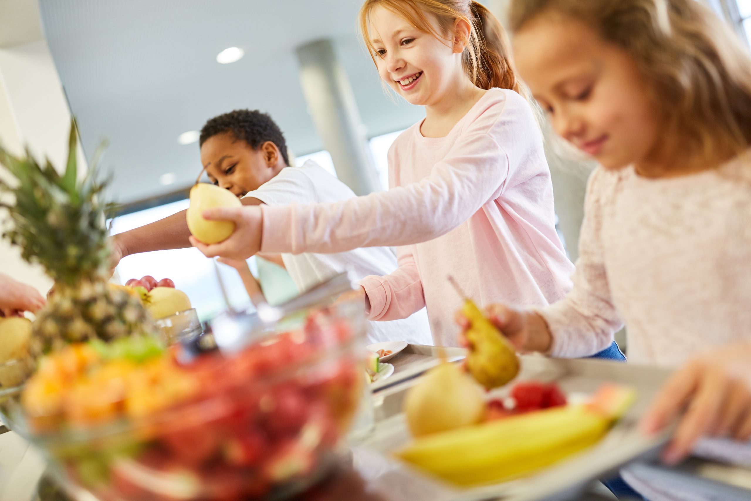 Niños y niñas comiendo fruta fresca